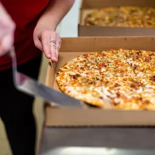 a person cutting a pizza