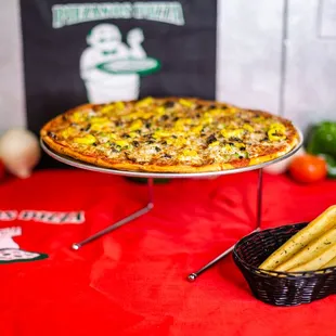 a pizza and a basket of breadsticks