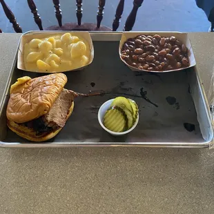 Brisket sandwich with two sides of beans and Mac and cheese