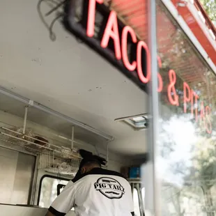 a taco truck with a man standing at the counter