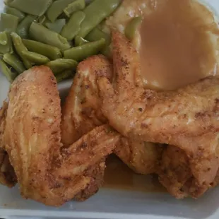a plate of fried chicken with gravy and green beans