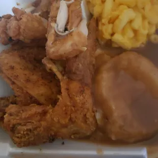 fried chicken, macaroni and cheese and gravy in a styrofoam container
