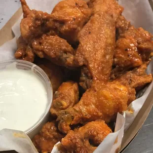 a basket of chicken wings with a side of ranch dip
