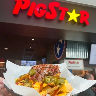 a person holding a plate of food in front of a restaurant