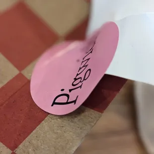 a piece of paper with a pink sticker on it