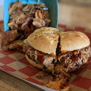 a pulled pork sandwich and potato chips