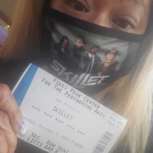 a woman holding a concert ticket