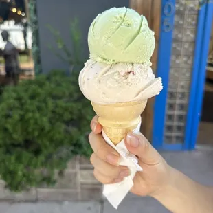 a hand holding an ice cream cone