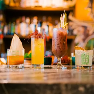 a variety of cocktails on a bar