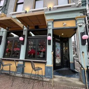 the outside of a restaurant with tables and chairs