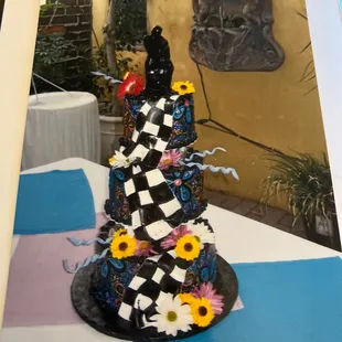 Our wedding cake was a 3 tiered, race flags, hand drawn art and flowers theme. It was a whimsical cake.