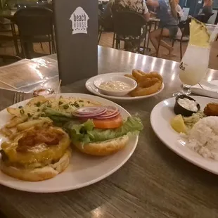 My bacon cheese deluxe burger   N wife&apos;s fish n rice with side order onion rings