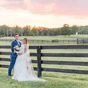 Horse farm wedding couple by paddock fence,