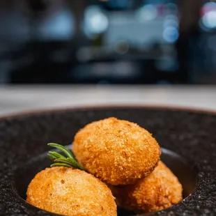 three pieces of deep fried chicken nuggies on a black plate