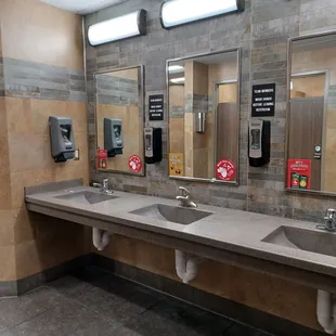 a public restroom with three sinks