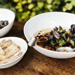 a bowl of mussels and bread