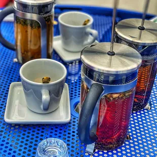 a blue table with cups of tea