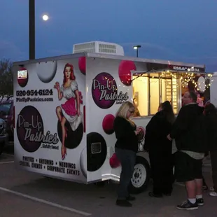 a group of people standing in front of a food truck