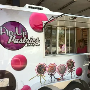 a woman standing in front of a food truck