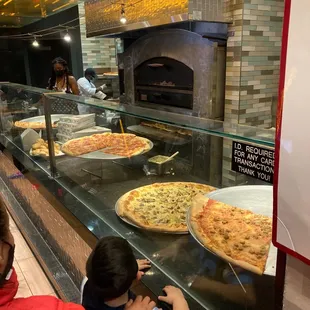 a woman taking a picture of a pizza