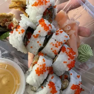 a person holding a container of sushi