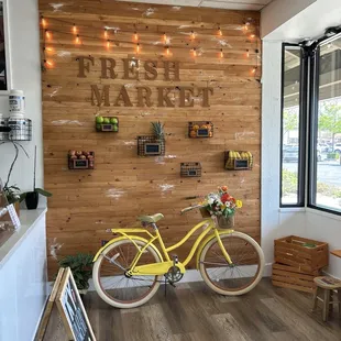 a yellow bicycle in front of a wooden wall