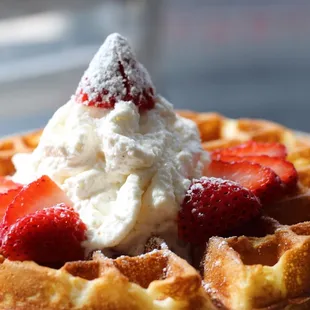 a waffle with whipped cream and strawberries