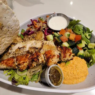 Tilapia and chicken kabob salad with hummus, Mediterranean salad, sauteed onions and slaw