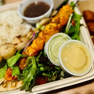 Shrimp Kebab platter with black beans, white rice, salad, pita bread, and a side order of chicken kebab.