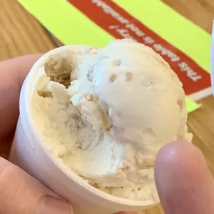 a hand holding a scoop of ice cream