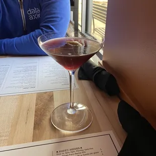 a man sitting at a table with a glass of wine
