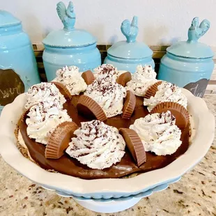 a chocolate pie with frosting and candy bars