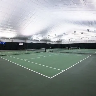 Climate controlled cushioned indoor tennis courts.