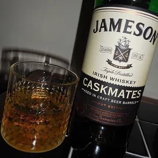 a glass of whiskey and a bottle of jameson