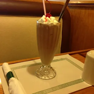 a chocolate milkshake with whipped cream and cherries