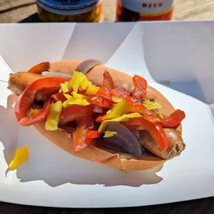 a hot dog with peppers and mustard