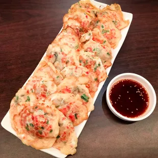 a plate of pizza and a small bowl of sauce