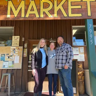 three people standing in front of the store