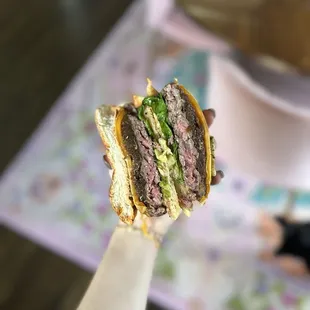 a hand holding a sandwich