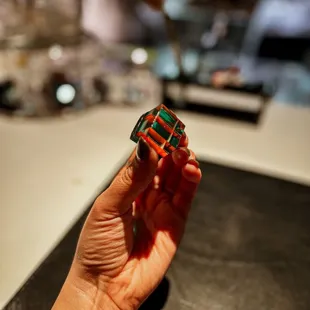 a hand holding a small puzzle piece