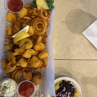 Shrimp basket with hush puppies and curly fries and black beans with rice.
