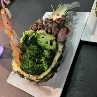 a pineapple with broccoli and shrimp