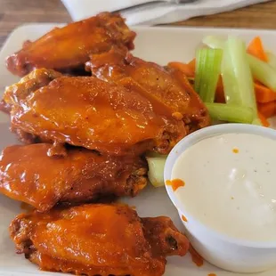 a plate of chicken wings with ranch dressing