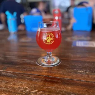 a glass of beer on a wooden table