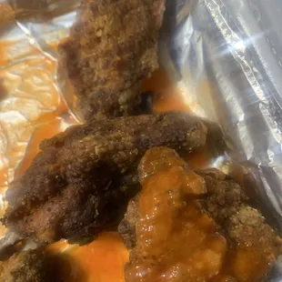 Burnt wings. Looks like they are old. Likely the cook making them ahead of time because it was busy and then refried.