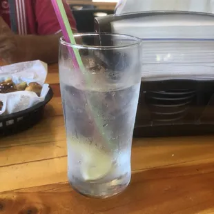 a glass of water with ice and a straw