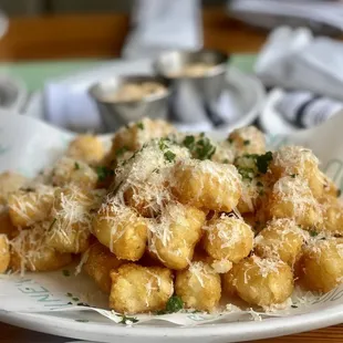 a plate of tater tots with parmesan cheese