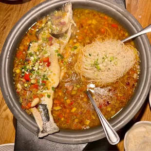 a bowl of soup with noodles and fish