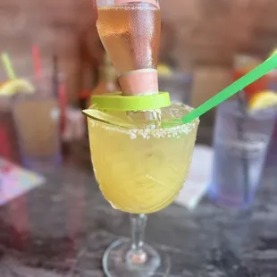 a glass of lemonade with a green straw