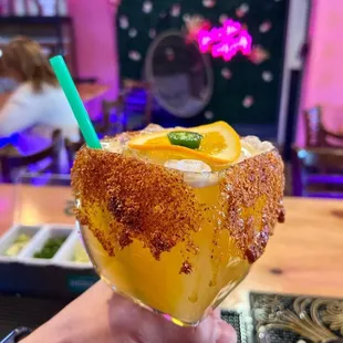 a person holding a glass of orange juice